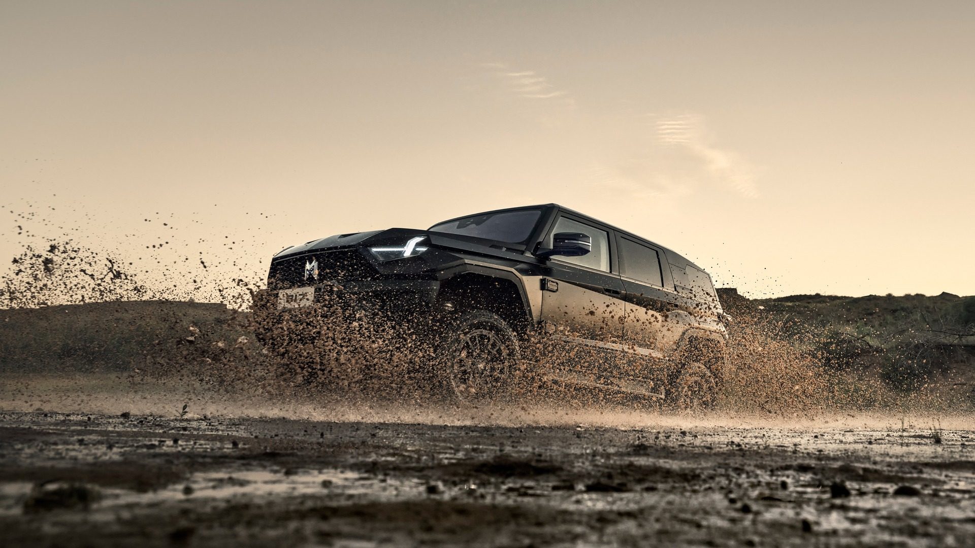 MHero 917 in black, side view, driving through mud